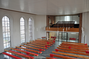  Der schlichte Gottesdienstraum – hier der Blick Richtung Eingang – wird geprägt von den großen neugotischen Fenstern. 