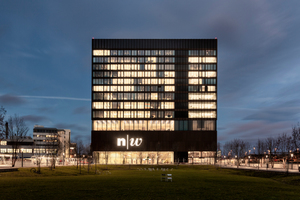  Der 65 m hohe Kubus der Fachhochschule Muttenz türmt sich über die Weite des angrenzenden Gleisfelds, eingeleitet durch einen von Baumreihen gesäumten Park und einen großzügigen Vorplatz. 