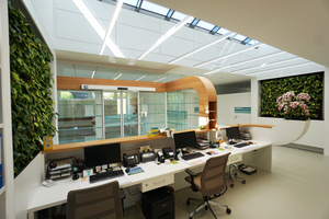  Im Empfangsbereich des Ärztezentrums verschmelzen Architektur und Mobiliar – unterstützt von Wandbändern in heller Kirschholzoptik und 4 m2 großen Pflanzenwänden – zu einem organischen Ganzen. 