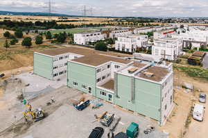  Um möglichst schnell zusätzliche Grundschulplätze bereitstellen zu können, ließ die Stadt Frankfurt am Main im Stadtteil Riedberg ein Übergangsquartier aus 166 Stahlmodulen errichten. Obwohl als temporärer Bau geplant und errichtet, setzte der Bauherr auf eine hochwertige Klima- und ­Lüftungstechnik. 