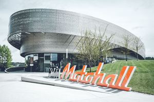  Die KTM Motohall am Stammsitz Mattighofen bietet für jeden Besucher ein einzigartiges Erlebnis. Perforierte Metallbänder, ein Sinnbild von Reifenabdrücken, umkurven den modernen Stahlbetonbau.  