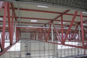  Dachkonstruktion der Halle – Blick von Süden auf die geschlossene Nordwand der Halle. Die Rohrtrassen für die Notentwässerung waren so einzufügen, dass der Betrieb von Kranbahnen weiter möglich war und die Durchfahrtshöhe nicht eingeschränkt wurde. 