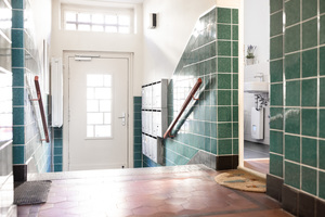  Ein Blick vom Hausflur in das Bad einer Wohnung, der nach der Renovierung ebenfalls hell und freundlich wirkt 