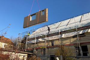  Industriell gefertigte Dach- und Fassadenelemente werden per Tieflader geliefert und mit dem Kran an ihren Bestimmungsort gebracht – hier bei einem Pilotprojekt in Hameln. 