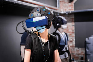 YULLBE-Besucherin mit Tracking-Helm und VR-Brille. 