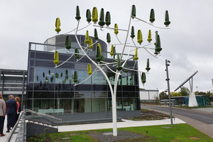  Pavillon mit Leitwarte und Besprechungsräumen, davor ein Windbaum, mit 36 Blättern, sogenannten Aeroleafs, die durchschnittlich ca. 10,8 kWp Strom erzeugen können.  
