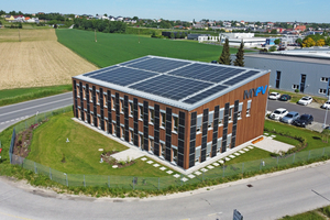  Auf dem Firmengebäude von my-PV wurden insgesamt 100 kW<sub>p</sub> Photovoltaik auf dem Pultdach und an der Fassade installiert. Die Bodenplatte des Gebäudes dient als Speicher für einen Teil des erzeugten Solarstroms, indem dieser dort in Wärme umgewandelt wird. Die Konstruktion basiert auf einer Holzleichtbauweise, sie erreicht den Effizienzstandard eines Niedrigenergiegebäudes. 