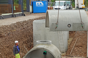  Montage der Betonfertigteile zu einem unterirdischen Sickertunnel. Im Hintergrund der Substratfilterschacht, der neben mineralölhaltigen Kohlenwasserstoffen auch Feststoffe wie Reifenabrieb und die Schwermetalle Kupfer und Zink aus dem Wasser entfernen kann. Das Retentionsvolumen wurde mit einem Simulationsprogramm nach DWA-A 138 bemessen. 
