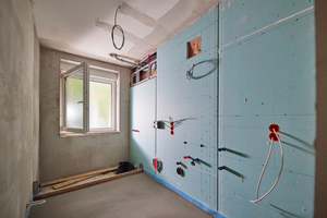  Blick ins künftige Badezimmer: Die raumhohe Trennwand ist fertig beplankt, die Leitungen für die Anschlüsse sind herausgeführt.  
