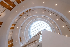  Gewendelte Treppen und leicht versetzte Etagen unter einer zentralen Glaskuppel verstärken den luftigen Effekt dieses Rundgebäudes.  