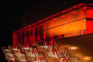  Die EmslandArena mit illuminierter Fassade bei Nacht  