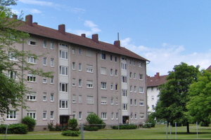  Fassade eines Gebäuderiegels vor der Sanierung  