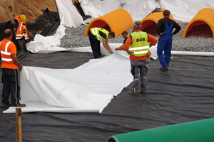  Unterirdisches Retentionssystem mit schwarzer PEHD-Folie, darauf Geotextil und Schottermaterial als Grundlage für die Birco-Rigolentunnel von StormTech.  