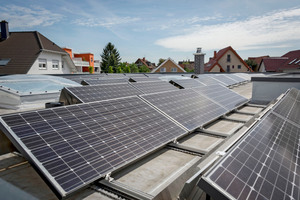  Heinz Jörg Göbert auf dem Flachdach seines Bungalows inmitten von 69 Photovoltaikmodulen 