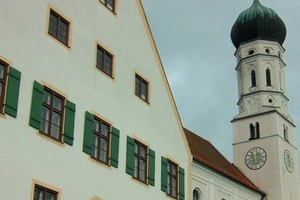  Pfarrhof in Pähl, seit 2011 mit Option zum Anschluss am Nahwärmenetz, dahinter die Kirche Sankt Laurentius 