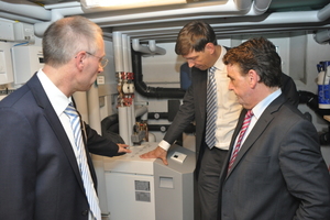  Andreas Klapdor und Dr. Norbert Verweyen (beide RWE) mit dem Minister für Bauen und Wohnen in NRW, Michael Groschek (von links) im Technikraum des Effizienzhauses an der Stiebel Eltron-Wärmepumpe      